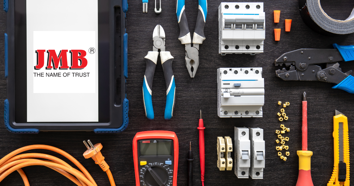 Electronics workshop showcasing essential tools and components used in electrical projects, including the JMB logo, emphasizing their role as a trusted Fan Regulator Manufacturer in India.