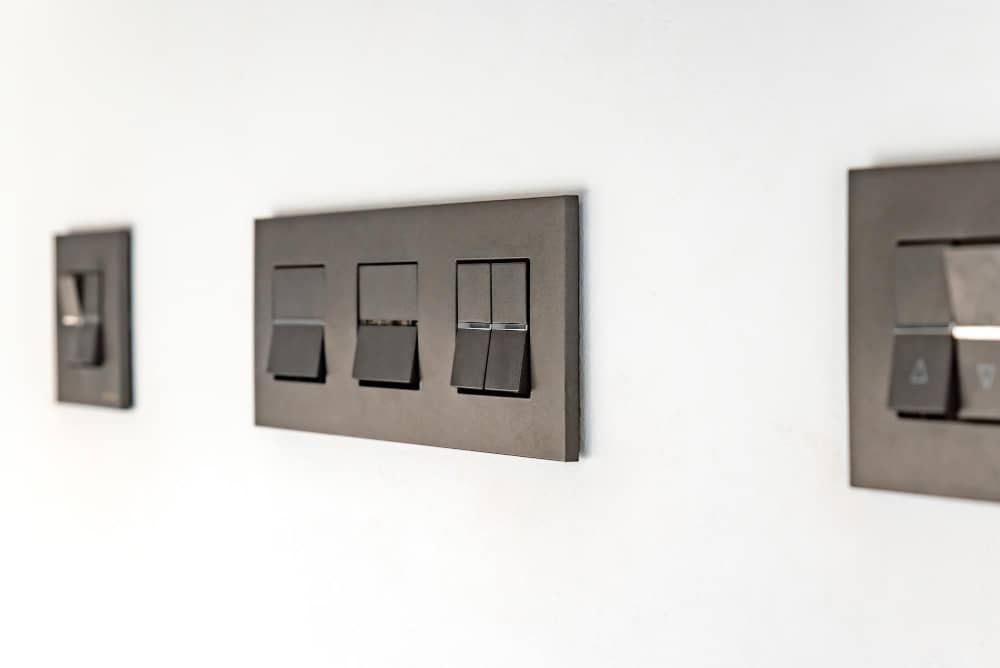 A modern black modular switchboard with multiple switches, designed with high-quality materials by top fan regulator manufacturers in India.