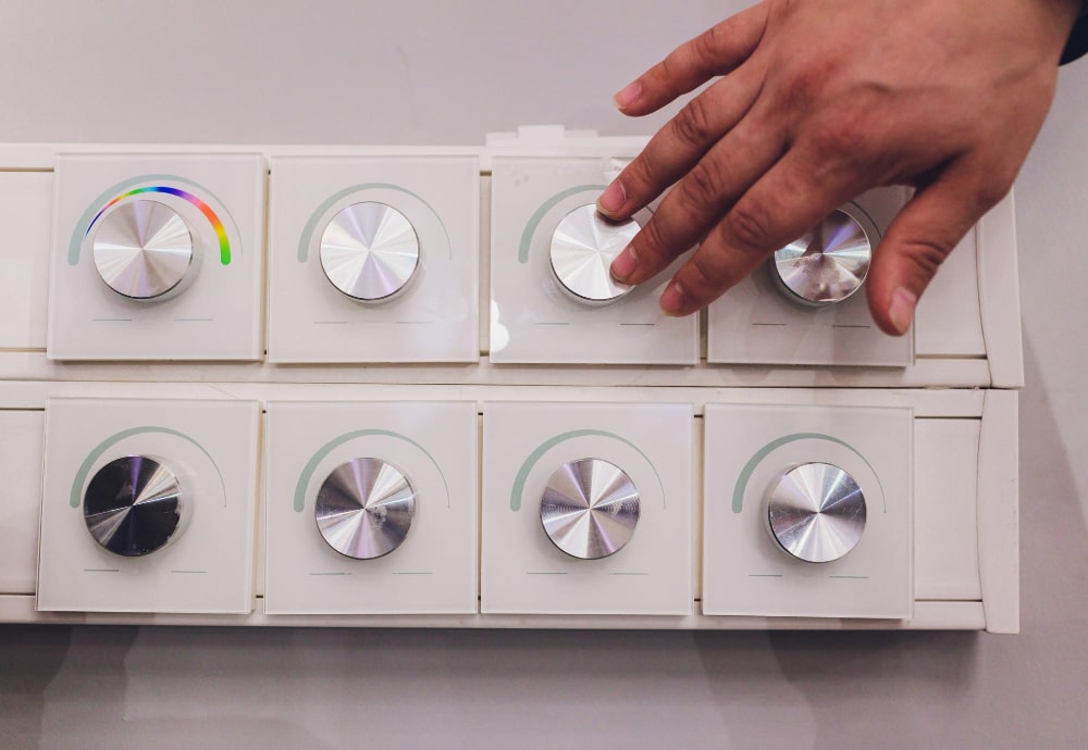 A hand adjusts a modern, touch-sensitive rotary fan regulator, showcasing the sleek design from leading fan regulator manufacturers.